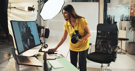 Editing, photographer and woman with camera, computer and creative for project in studio or serious. Business, artist and person with tech for photography, post production and choice of picture