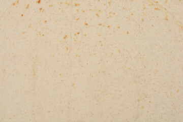 A close-up of the the speckled texture of a tortilla, revealing its subtle variations in color and surface details