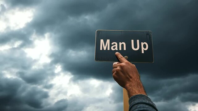 A hand crushing a "Man Up" sign representing toxic masculinity