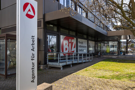 Au&szlig;enansicht der Agentur f&uuml;r Arbeit mit dem Berufsinformationszentrum (BiZ). Im Vordergrund steht ein Schild mit dem Logo der Bundesagentur f&uuml;r Arbeit. 