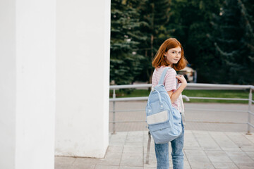 Fototapeta premium Teen girl in casual wear with backpack near school campus