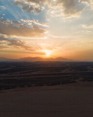 Dramatic sunset over Red Sea mountains with golden clouds, Egypt