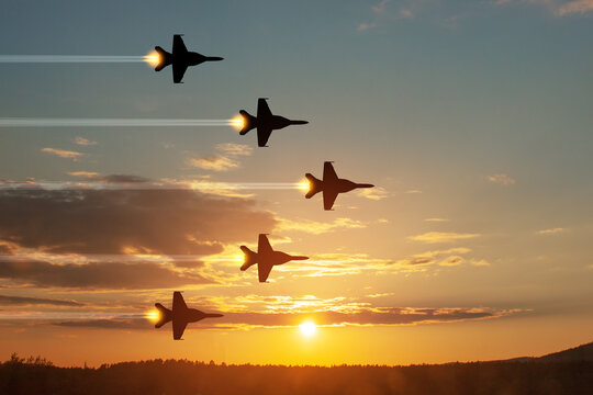 Air Force Day. Aircraft silhouettes on background of sunset. Combat flight of interceptors on a mission.