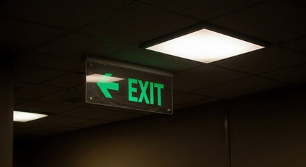 Illuminated Exit Sign with Arrow in Dark Interior Space