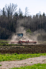 Fototapeta premium A tractor plows a field in early spring.