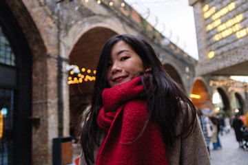 Young woman smiling wearing red scarf in market