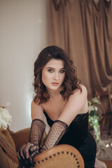 Fototapeta premium Elegant woman with lace gloves sitting in a vintage room