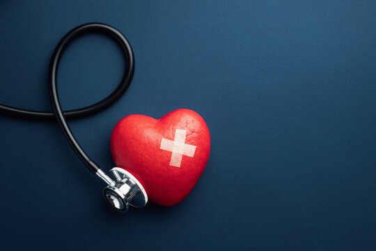 Red heart with doctor stethoscope on blue background, hospital life insurance concept, world heart health day. doctor day. Copy space. Top view.