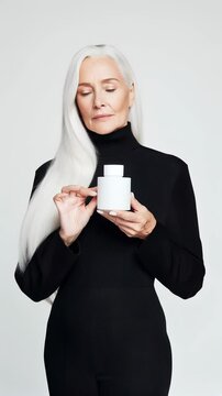 Elegant woman with long silver hair presents a minimalist bottle. Ideal for Social Media, Stories, Advertising