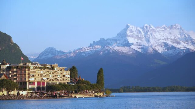 Beautiful summer evening panorama of Lake Geneva with picturesque shores against Alpine mountains in the rays of the setting sun in Montreux, Switzerland