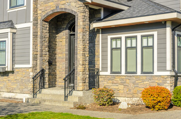Entrance of grey painted luxury house in summer with stair steps and nice landscape in Vancouver,...