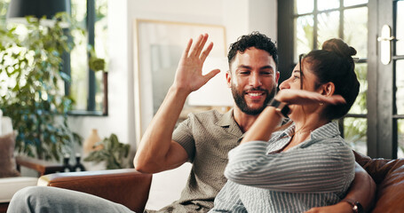 High five, conversation and couple with relax, joke and bonding together in home lounge. Smile,...