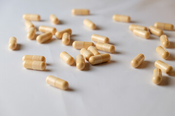 Natural dietary supplements scattered on a clean white surface for wellness