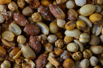 Fototapeta premium Colorful assortment of roasted nuts displayed in a rustic wooden bowl at an outdoor gathering during a sunny afternoon