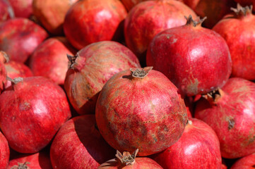 Vibrant pomegranates stacked together showcasing their rich color and freshness at a bustling...