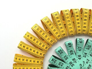 Close-up of two twisted colored measuring tapes