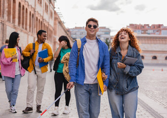Blind university student walking with friends on campus