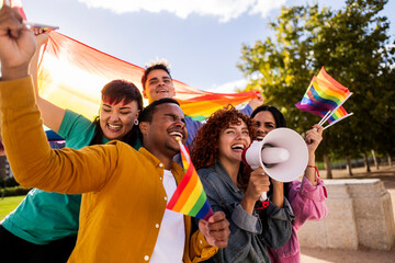 Obraz premium Happy activists protesting for lgbtq plus rights holding rainbow flags and megaphone