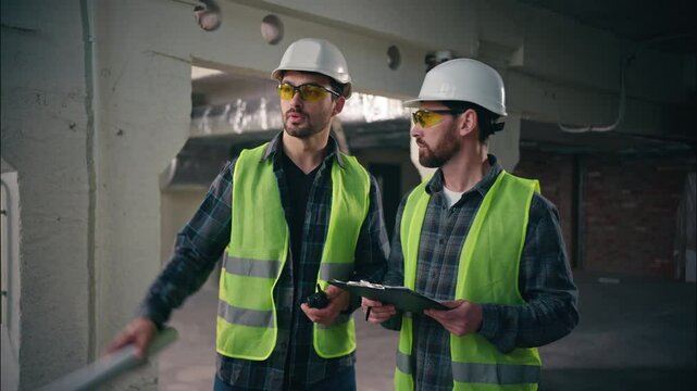 Professional Caucasian architects males guys foremen mechanics teamwork men miners speaking building industrial construction builders employees talking walkie talkie in factory engineers supervising