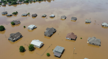 Aerial view of flooded residential area with houses partially submerged in brown water. Natural disaster concept for flood insurance and climate change awareness