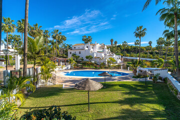 Exclusivo complejo residencial con piscina rodeado de palmeras en un entorno tropical