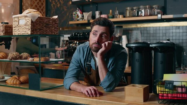Frustrated Caucasian bartender man staff guy waiting clients in coffee shop bored employer working small business owner feeling stress cafeteria upset male barista no customers problem cafe difficulty