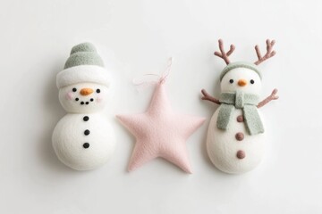 Two adorable needle felted snowmen, one with antlers, and a pink star ornament.