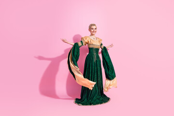 Fototapeta premium Glamorous woman in medieval royal dress posing gracefully against pink background