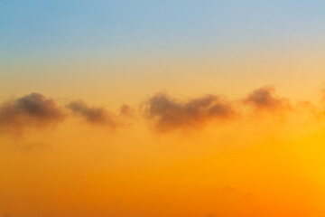 Fototapeta premium Clouds and orange sky,Beautiful Vivid sky painted by the sun leaving bright golden shades,Yellow sunlight in Golden hour or morning sunrise, Horizon sky nature background
