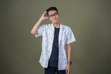Asian man with glasses wearing white casual shirt posing thinking, dizzy or looking for ideas....