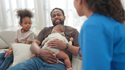 Obraz premium A doctor uses a stethoscope to check on the health of a little boy as he sleeps in his father's arms