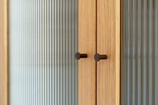 Modern home interior with wooden cabinet and reeded glass door