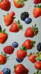 Berry Mix in Motion &ndash; Strawberries, Blueberries, Raspberries and Blackberries on Light Background, Healthy Food Concept