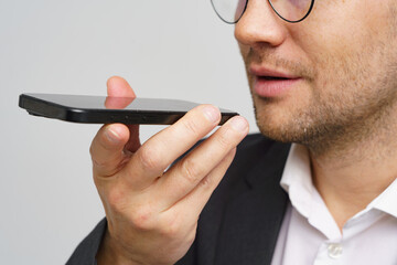 Man using smartphone to engage in voice command while dressed in business attire indoors