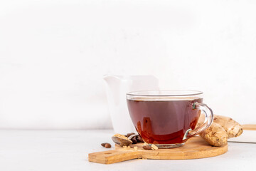 Fresh brewed ginger coffee cup. Dark coffee espresso hot drink with ginger powder and ginger root, on white background. Healthy hot drink. alternative medicine, remedy 