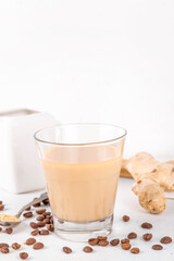 Fresh brewed ginger coffee latte cup. Creamy hot drink with ginger powder and ginger root, on white background. Healthy hot beverage. alternative medicine, remedy 