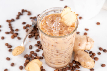 Cold brewed ginger coffee latte cup. Creamy iced drink with ginger powder and ginger root, on white background. Healthy hot beverage. alternative medicine, remedy 