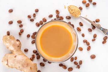 Fresh brewed ginger coffee latte cup. Creamy hot drink with ginger powder and ginger root, on white background. Healthy hot beverage. alternative medicine, remedy 