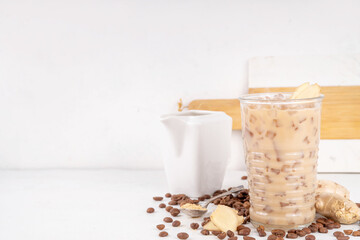 Cold brewed ginger coffee latte cup. Creamy iced drink with ginger powder and ginger root, on white background. Healthy hot beverage. alternative medicine, remedy 