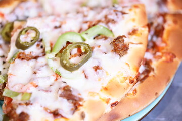 A delicious-looking pizza with various toppings and sauce, served on a white plate.