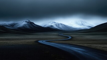Winding road through a dramatic, snowy mountain landscape.  A dark, moody, and atmospheric vista