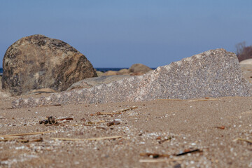 Weathered Stone Fragment on a Sandy Beach with Coastal Boulders