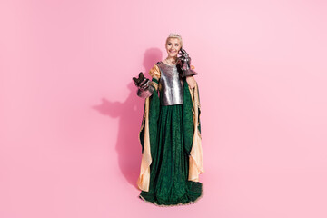 Fototapeta premium Elegant woman in medieval royal attire on a pink backdrop