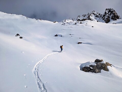 Skier tracks through fresh deep snow. First line up and down. Ski mountaineering on the Gorihorn above the Davos Klosters Mountains. Ski touring trail. Skimo in the Alps. High quality photo.