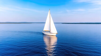 Obraz premium Sailboat glides across serene water. Clear sky and calm waters reflect the vessel