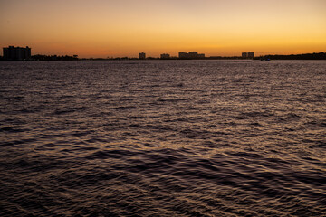 Sunset over calm waters with silhouettes of Miami