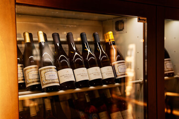 Milan, Italy - October 3, 2024: Bottles with collection wines stand on shelves in a wine...