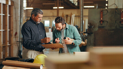 Clipboard, teamwork or people in woodworking factory for warehouse inventory, plan or furniture production. Carpentry, carpenter or project progress update for timber, lumber or construction business