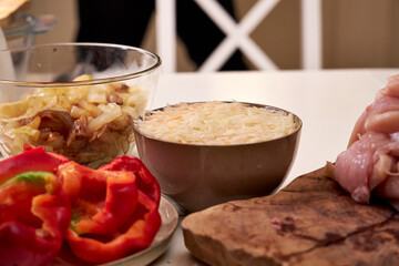 ingredients, vegetables and meat on a white table in the kitchen