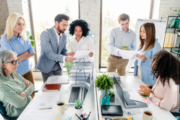 Diverse group of professionals collaborate in a modern office setting, focusing on teamwork and...